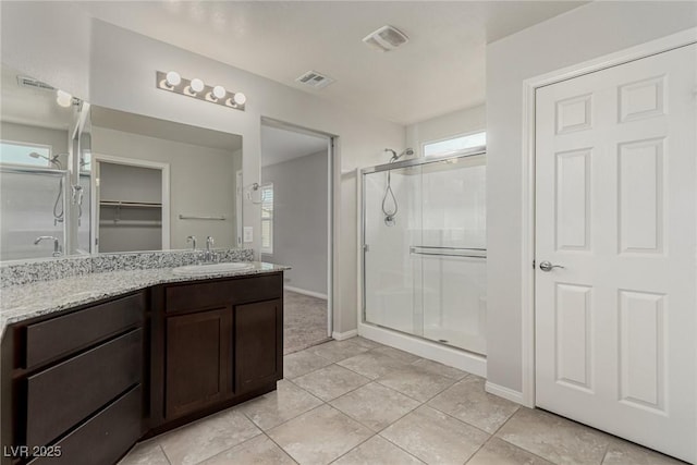 bathroom featuring vanity, a shower stall, and visible vents