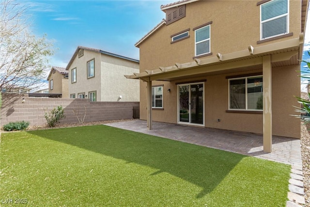 back of house featuring a patio, a yard, fence, and stucco siding