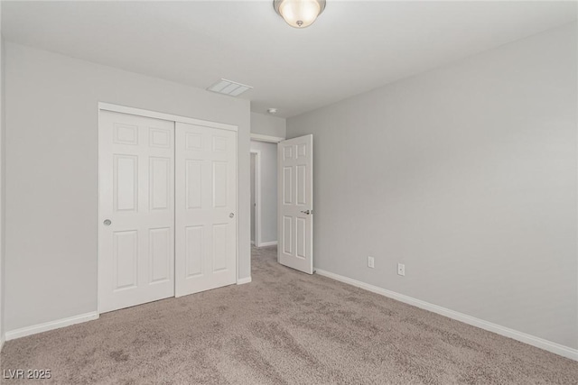 unfurnished bedroom featuring a closet, baseboards, and carpet