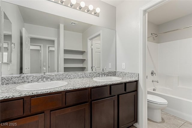 full bath with double vanity, shower / washtub combination, toilet, and a sink