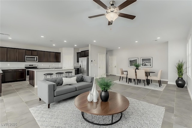 living room featuring visible vents, baseboards, ceiling fan, light tile patterned floors, and recessed lighting