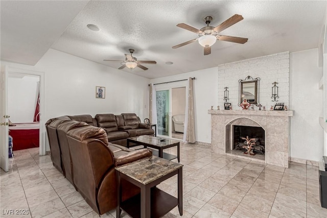 living room with a premium fireplace, a textured ceiling, marble finish floor, and ceiling fan