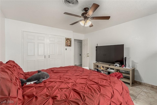 bedroom featuring visible vents, a ceiling fan, a textured ceiling, a closet, and baseboards