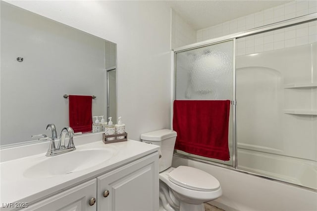 full bathroom with vanity, toilet, and bath / shower combo with glass door