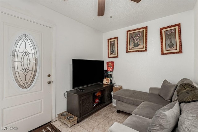 living room featuring light tile patterned floors, a textured ceiling, and a ceiling fan