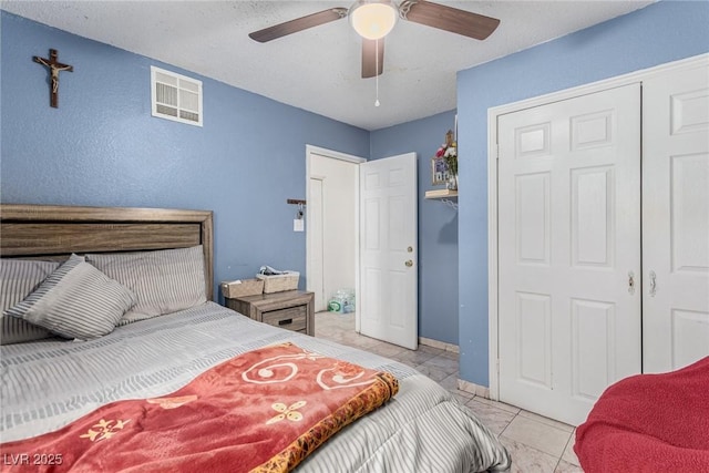 bedroom featuring light tile patterned flooring, visible vents, baseboards, and a ceiling fan