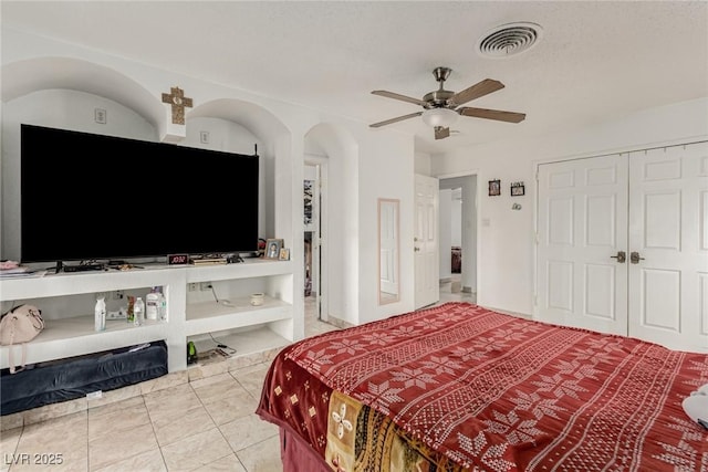 bedroom featuring a closet, visible vents, tile patterned flooring, and a ceiling fan