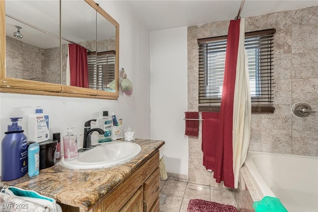 bathroom with tiled shower / bath combo, vanity, and tile patterned flooring