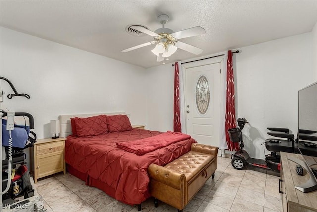 bedroom with a textured ceiling and ceiling fan