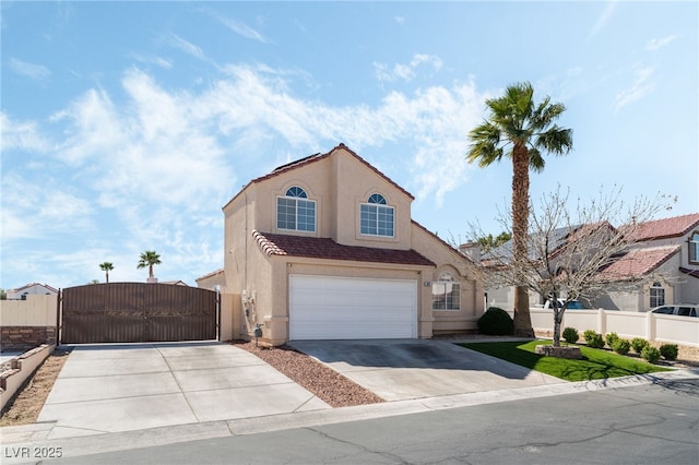 view of front of property featuring stucco siding, driveway, a gate, fence, and a tiled roof