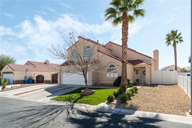 mediterranean / spanish home with fence, stucco siding, a garage, driveway, and a gate