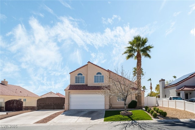 view of front of property with stucco siding, a tile roof, a gate, fence, and concrete driveway