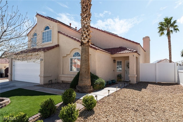 mediterranean / spanish-style home featuring fence, an attached garage, stucco siding, concrete driveway, and a tile roof