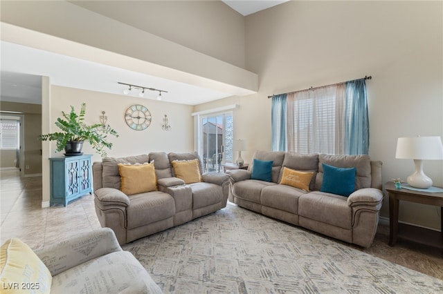 living room with light tile patterned floors, baseboards, a healthy amount of sunlight, and track lighting