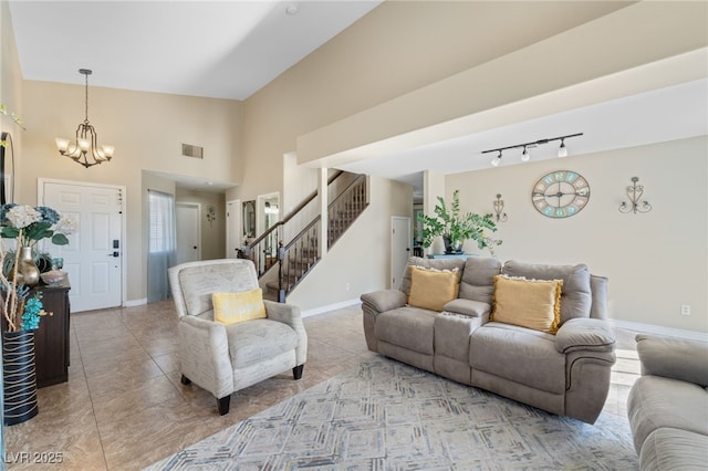 living area featuring visible vents, baseboards, a chandelier, stairway, and a high ceiling