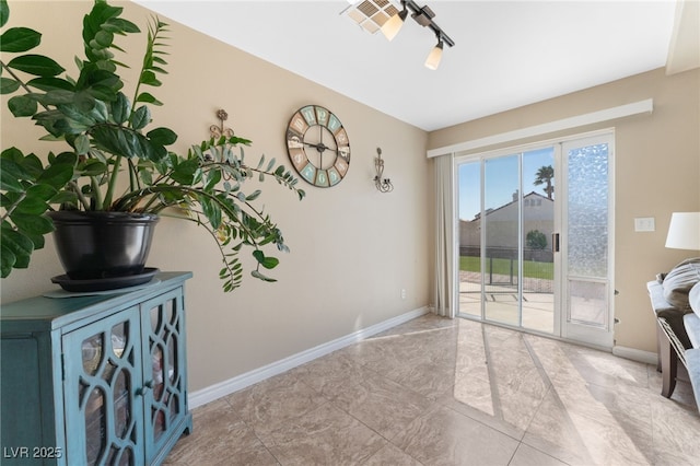 interior space with baseboards and track lighting