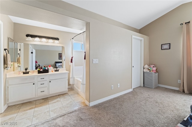 full bath featuring double vanity, baseboards, tile patterned floors, and a sink