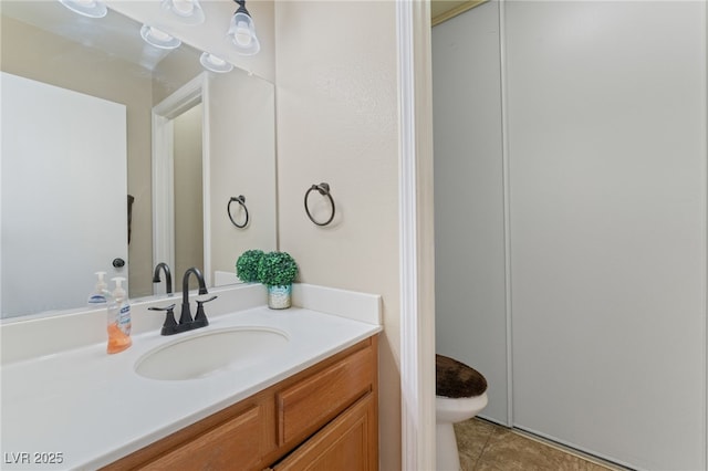 bathroom with tile patterned flooring, toilet, and vanity