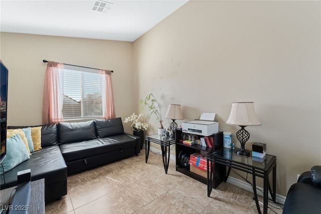 living area with baseboards and visible vents