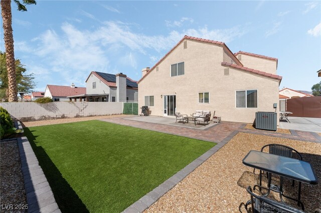 rear view of house with a fenced backyard, stucco siding, cooling unit, and a patio