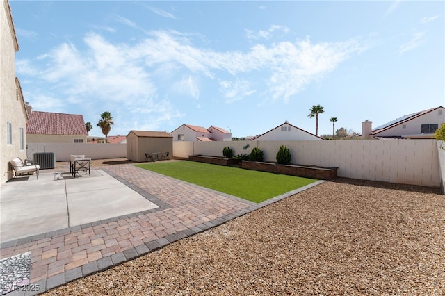 view of yard with central AC, a storage shed, a fenced backyard, an outdoor structure, and a patio