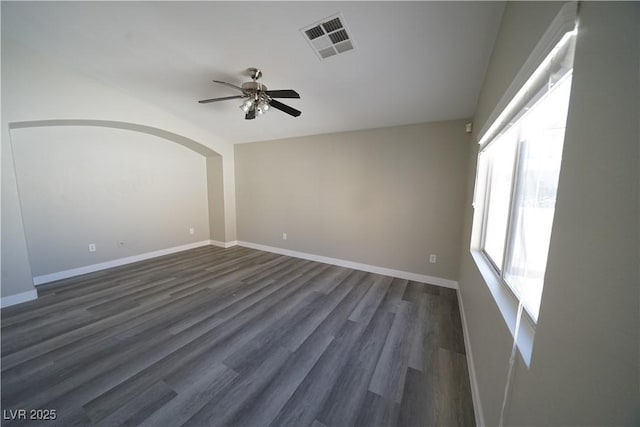 unfurnished room featuring visible vents, baseboards, a ceiling fan, and dark wood-style flooring