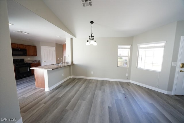 interior space with wood finished floors, baseboards, visible vents, and a sink