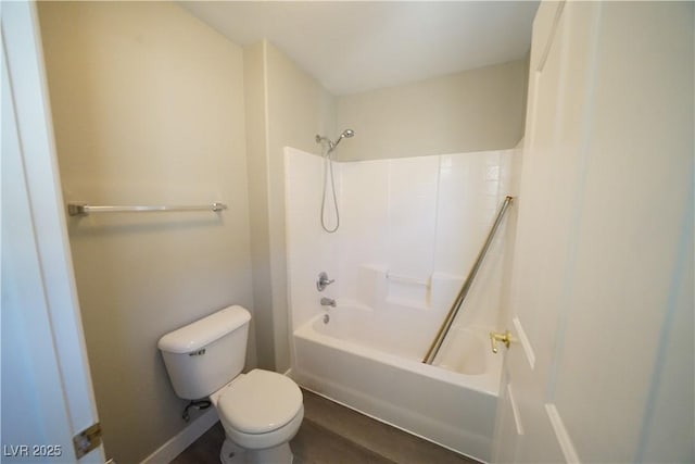 bathroom featuring shower / washtub combination, toilet, and baseboards