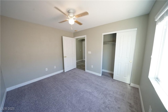 unfurnished bedroom featuring baseboards, multiple windows, and carpet flooring