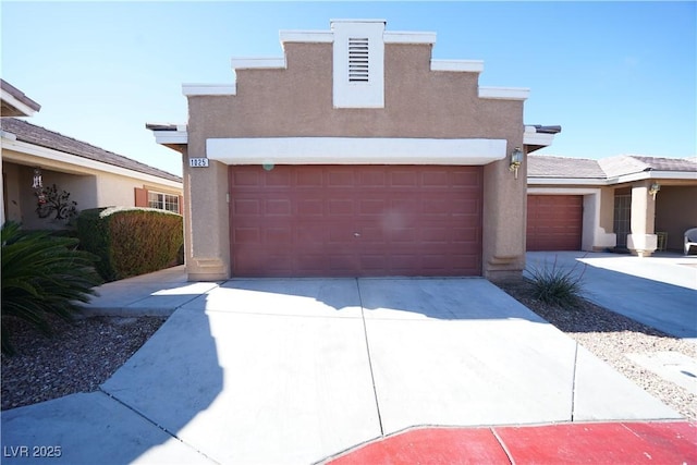 view of front of property featuring stucco siding, a garage, and driveway