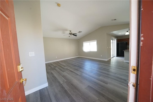 interior space featuring visible vents, baseboards, dark wood finished floors, vaulted ceiling, and a ceiling fan