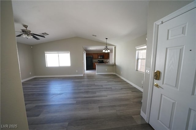 unfurnished living room featuring visible vents, a ceiling fan, dark wood-style floors, baseboards, and lofted ceiling