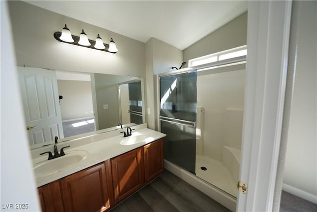 bathroom with a sink, a shower stall, and vaulted ceiling