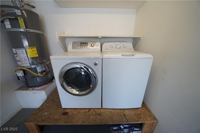 washroom featuring strapped water heater, independent washer and dryer, and laundry area