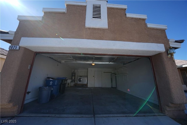 garage with washer / dryer, a garage door opener, and water heater