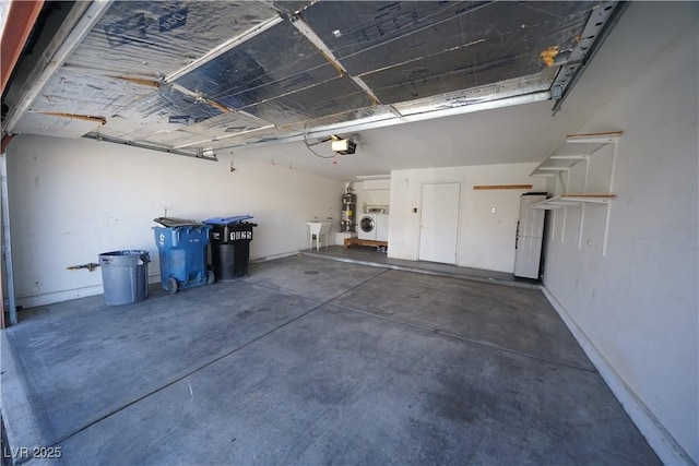 garage with washer / dryer, a garage door opener, and a sink