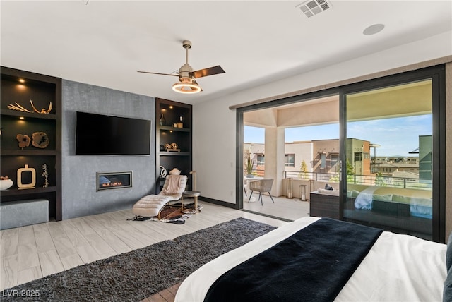 bedroom with visible vents, a large fireplace, baseboards, a ceiling fan, and access to outside