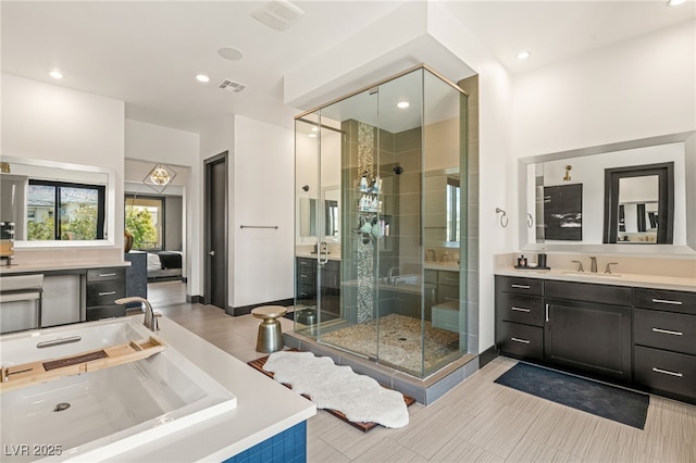 bathroom featuring visible vents, a tub to relax in, recessed lighting, a stall shower, and vanity