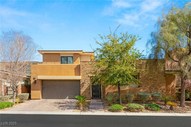 view of front of home with stone siding, stucco siding, driveway, and an attached garage