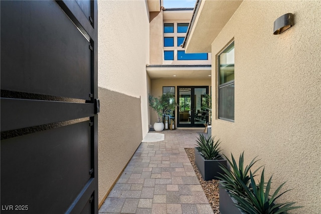 view of exterior entry with french doors and stucco siding