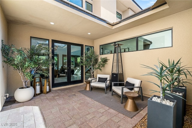 view of exterior entry featuring stucco siding and french doors