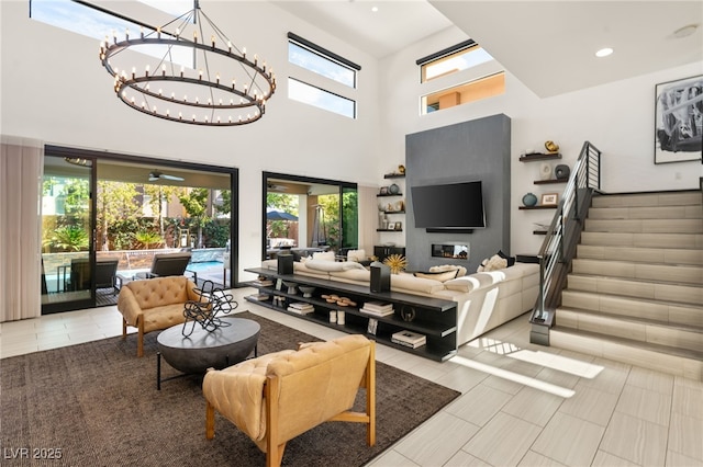 living room featuring stairway, recessed lighting, a high ceiling, and a chandelier