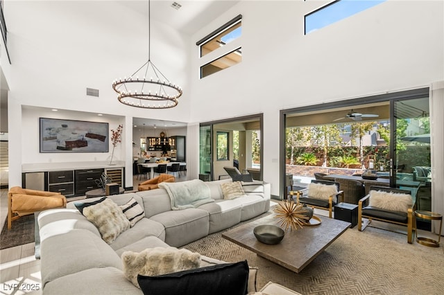 living room with visible vents, an inviting chandelier, and a healthy amount of sunlight