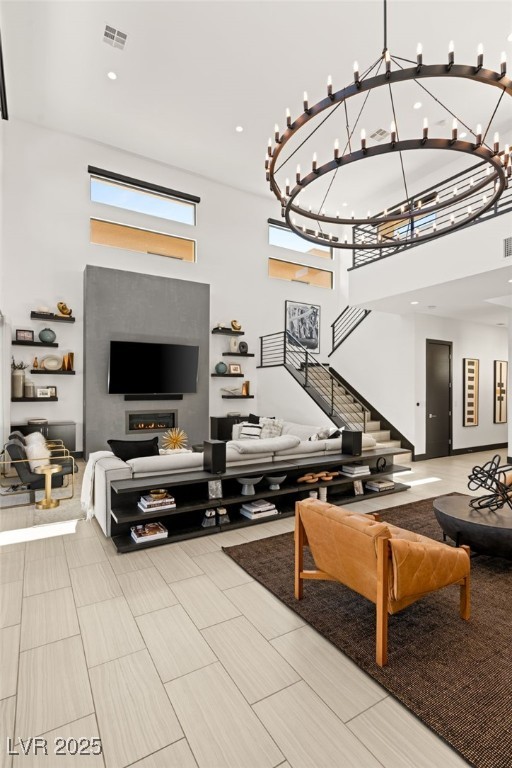 living area featuring visible vents, recessed lighting, stairs, and a towering ceiling