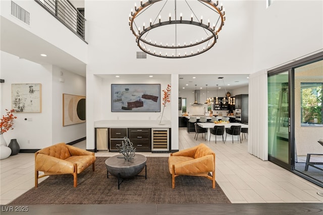 living room with visible vents, a notable chandelier, and beverage cooler