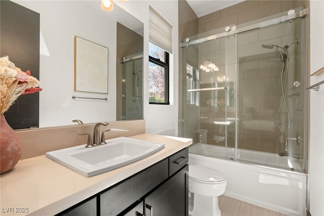 full bathroom with toilet, vanity, and bath / shower combo with glass door