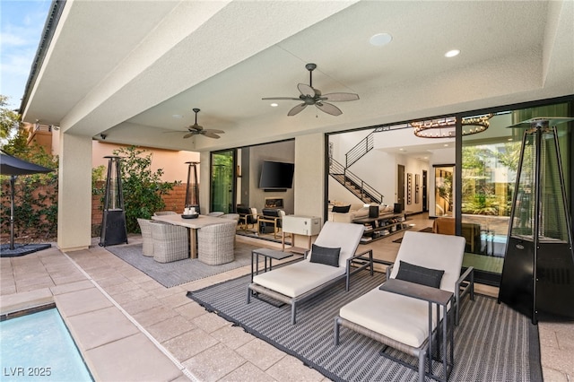 view of patio featuring stairs, outdoor dining area, and ceiling fan