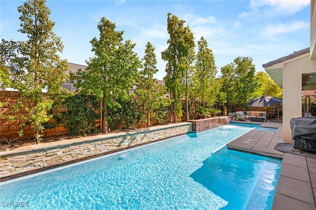 pool featuring grilling area, a patio, and a fenced backyard