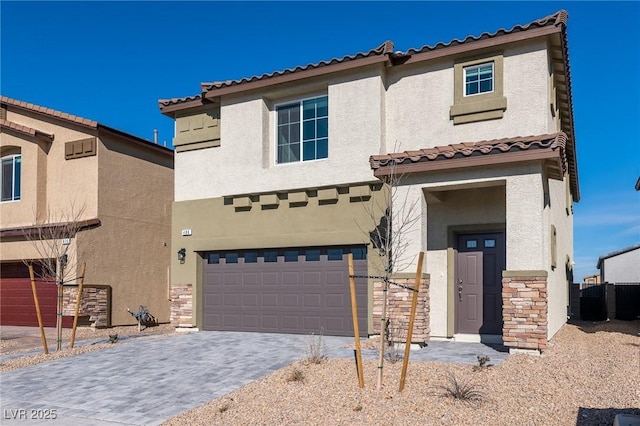 mediterranean / spanish-style home featuring decorative driveway, an attached garage, stone siding, and stucco siding