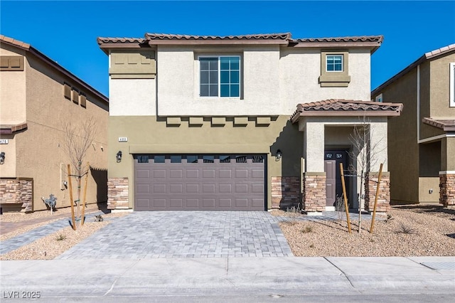 view of front facade with decorative driveway, an attached garage, stone siding, and stucco siding